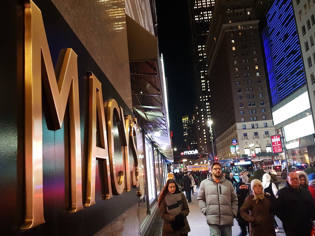 Letrero de bronce de Macys Herald Square Manhattan, gente caminando noche de invierno. Foto de Andrea Hoare Madrid