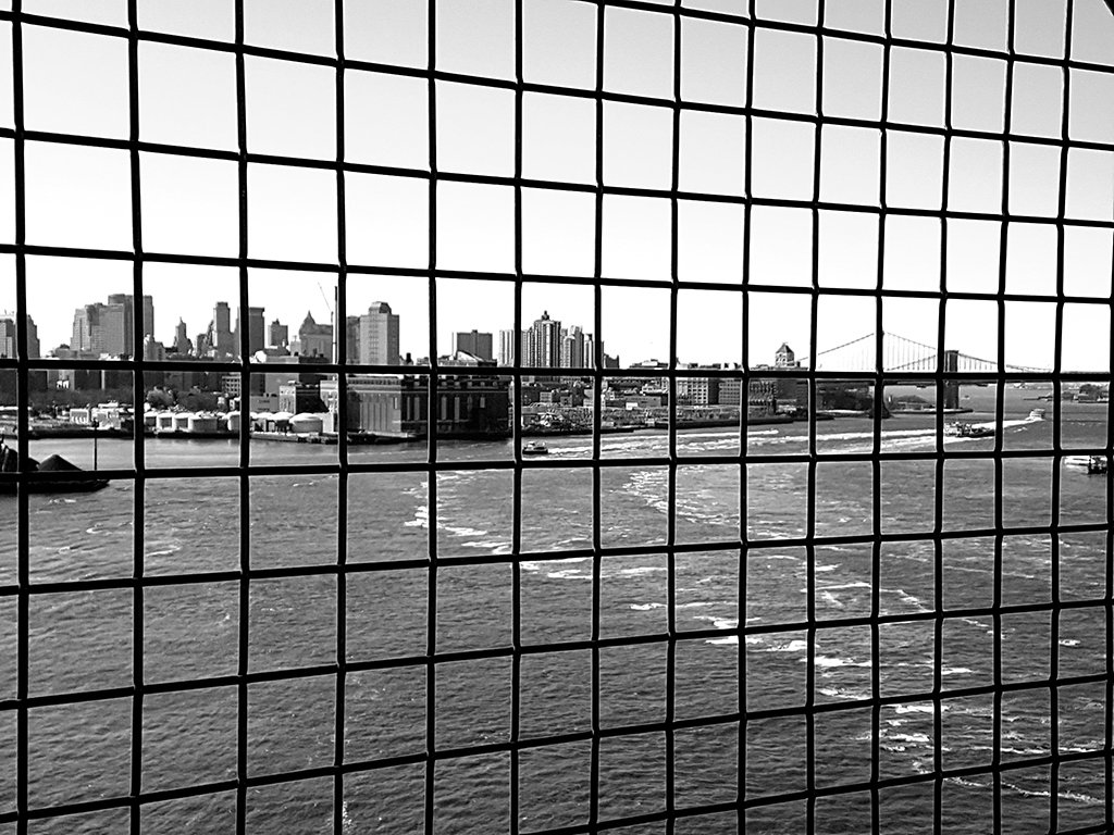 Puentes de Manhattan y Brooklyn vistos detrás de las rejas del cruce peatonal del Puente de Williamsburg - Foto de Andrea Hoare Madrid