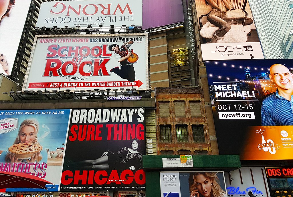 Letreros a musicales de Broadway sobre un edificio en el Distrito de los Teatros - Foto de AHM