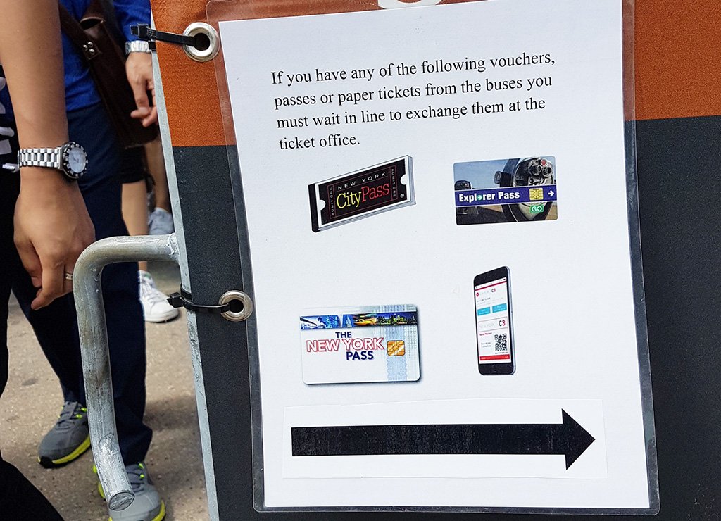 Letrero "Si tiene una tarjeta turística debe hacer la fila para canjear su entrada en la taquilla". Fila para las entradas con tarjetas de descuento en Castle Clinton, Battery Park - Foto de AHM