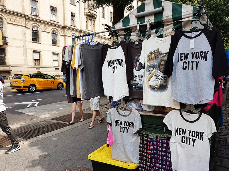 Puesto de ventas de T-shirts de John Lennon frente al Edificio Dakota y Central Park - Upper West Side - Foto de AHM