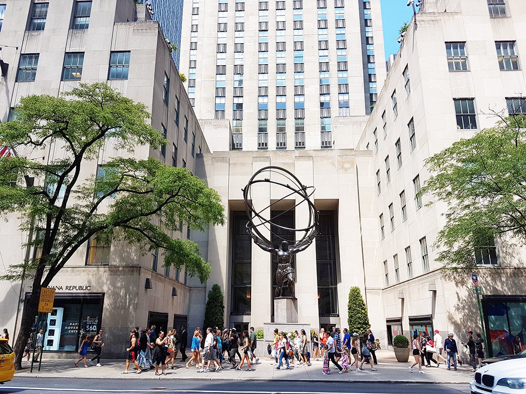 Gente caminando frente a la Estatua del Atlas del Rockefeller Center en la quinta avenida - Foto de AHM