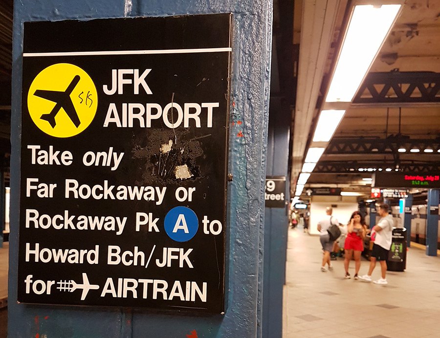 Letrero en una columna del andén de una estación de metro de Nueva York con instrucciones para llegar al Aeropuerto JFK- Foto de Andrea Hoare Madrid