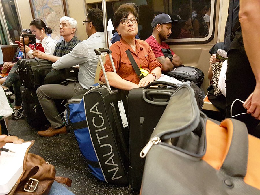 Gente viajando con maletas en el metro de Nueva York - Foto de AHM