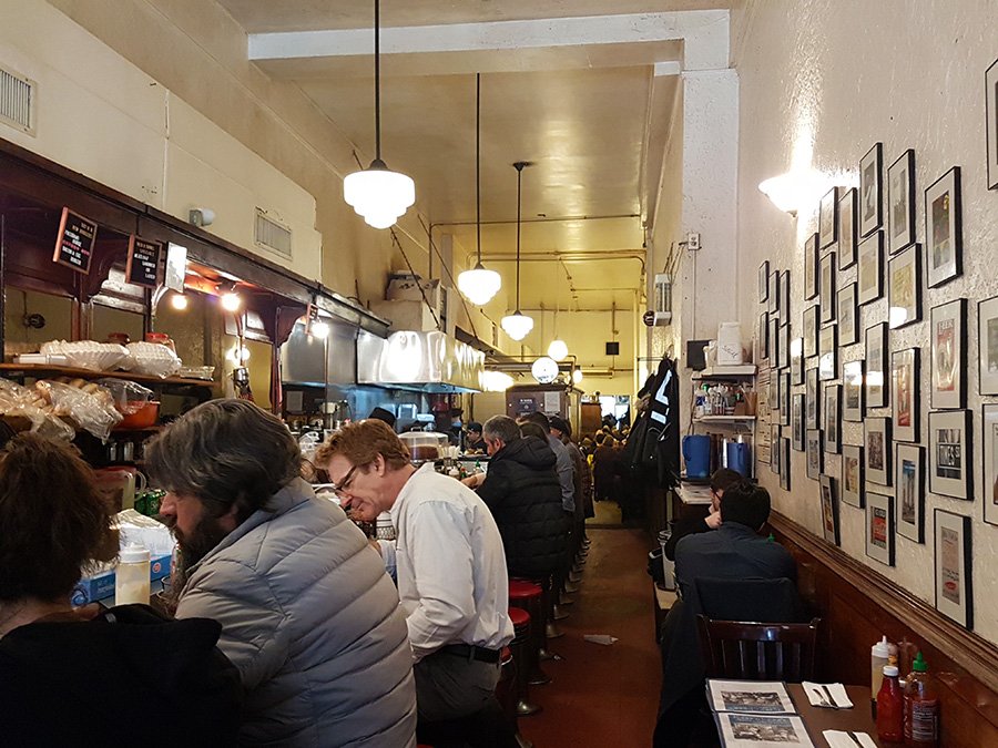 Barra y mesas al interior del local Eisenbergs Sandwich Shop, donde venden uno de los mejores sandwiches de pastrami de Nueva York - Foto de Andrea Hoare Madrid