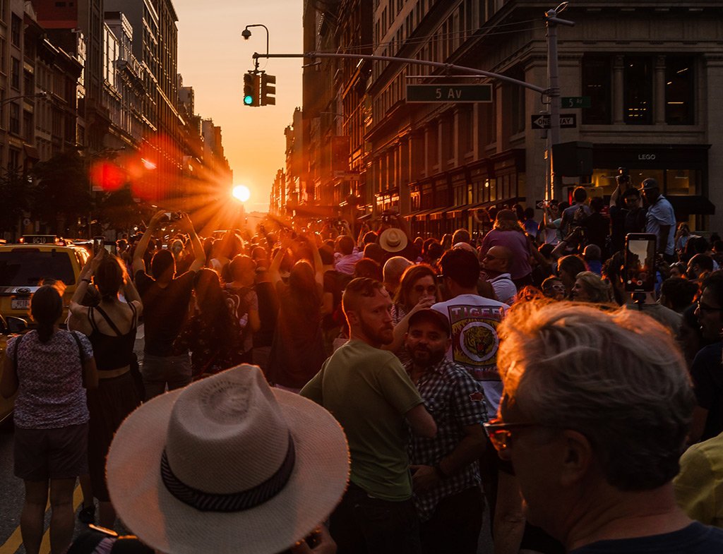 Personas fotografiando el Manhattanhenge, momento del año en que la puesta de sol coincide con las calles del centro de Manhattan. Foto de Mike Kareh en Unsplash disponible en https://unsplash.com/photos/Z8gmlhycZXMAlgo que hacer en julio en Nueva York