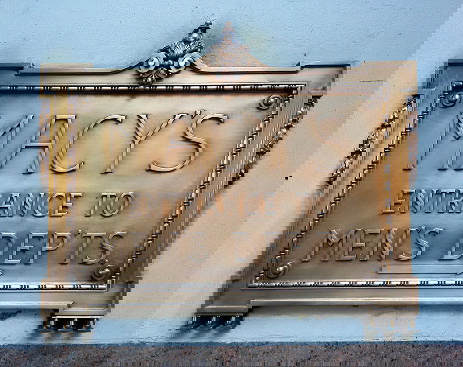 Antiguo letrero de bronce de Macy's indicando la entrada del departamento de hombres - Foto de Andrea Hoare Madrid