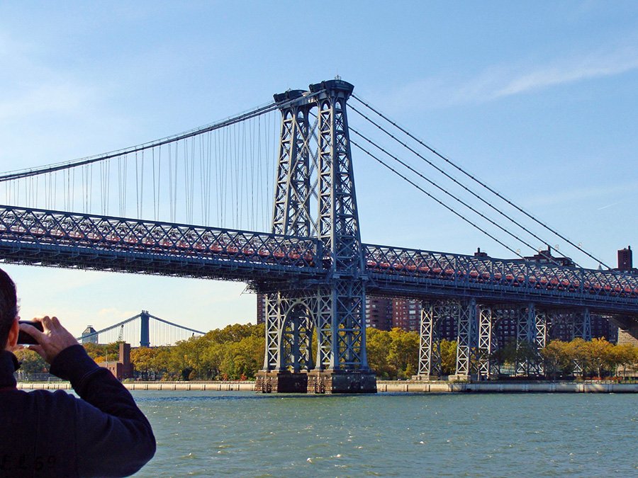 Persona sacando foto al Puente de Williamsburg visto desde el NYC Ferry en el East River - Fotografía de Andrea Hoare Madrid