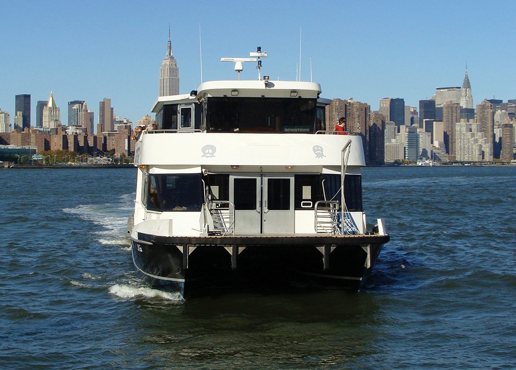 Embarcación del NYC Ferry llegando al muelle de Williamsburg, al fondo se ve el Empire State - Foto de AHM