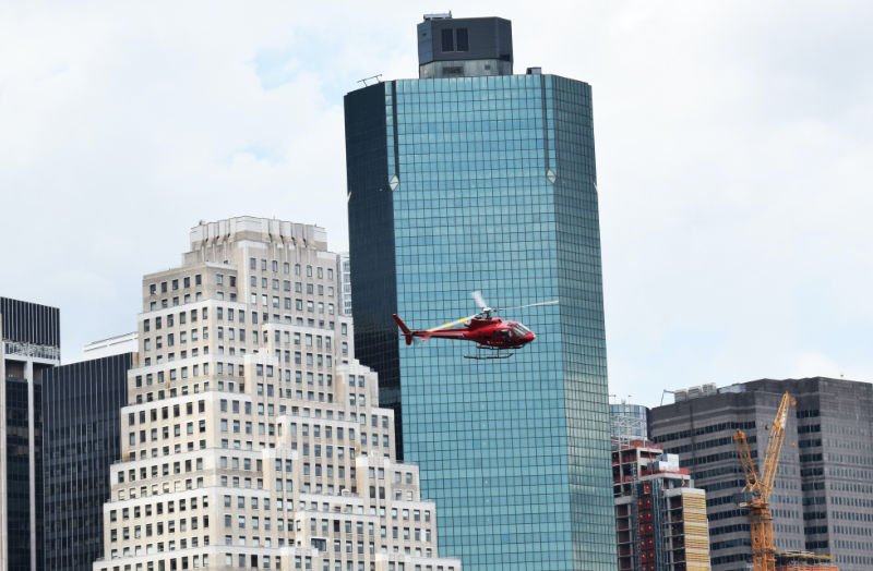 Helicóptero sobrevolando Manhattan, detrás se ven edificios del Distrito Financiero - Foto de Chris Barbalis en Unsplash disponible enhttps://unsplash.com/photos/KCWD18k1sR8