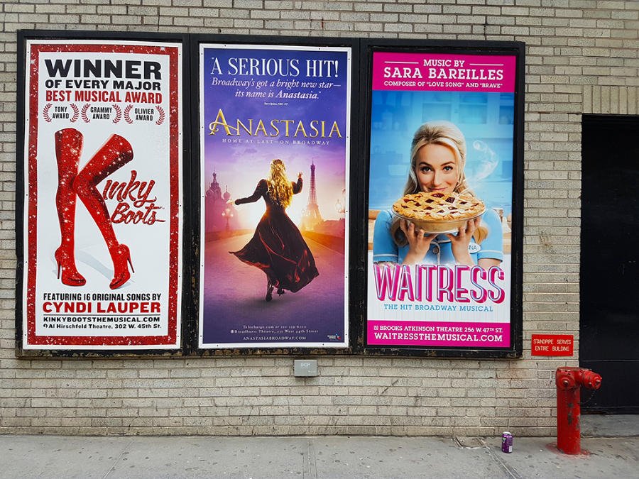 Letreros de los musicales Kinky Boots, Anastasia y Waitress junto a la salida de un teatro de Broadway en Manhattan - Foto de Andrea Hoare Madrid