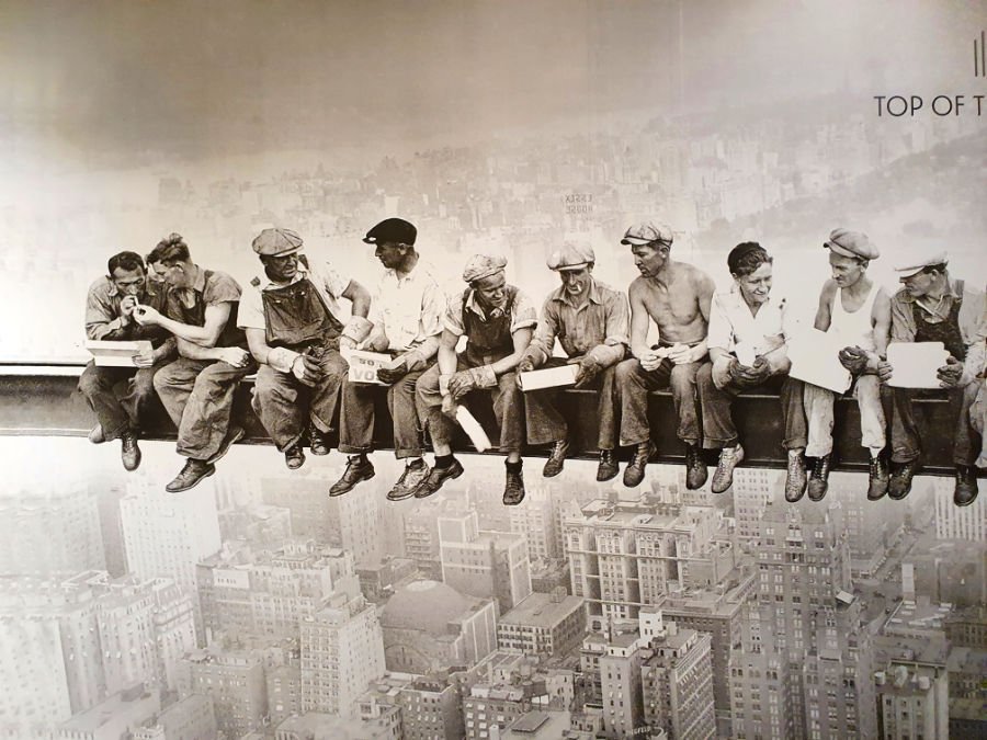 Fotografía de 1932 Lunch atop a skyscraper, almuerzo sobre un rascacielos en español. 11 obreros constructores del Rockefeller Center almorzando sobre un viga. Fotografía de la gigantografía de la famosa foto en el lobby de acceso al observatorio Top of the Rock en el Rockefeller Center - Foto tomada por AHM